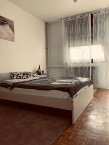 a bedroom with a large bed with a window at STUDIO APP STELLA Dnevni najam stana Jarun Zagreb in Zagreb