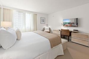 a white bedroom with a large bed and a desk at Oceanview Private Condo at 1 Hotel & Homes -915 in Miami Beach