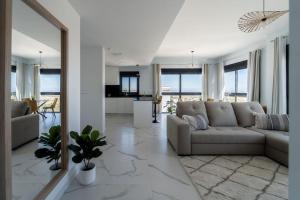 a living room with a couch and a kitchen at Royal Sunset close to Golf fields in San Miguel de Salinas