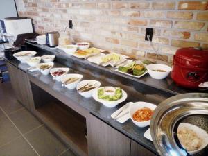 una línea de buffet con muchos platos de comida. en Jamsil 2.4 Hotel, en Seúl