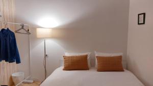 um quarto com uma cama com lençóis brancos e almofadas laranja em Nature Rooms-Cozy Cabin in the Woods 