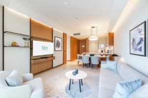 een woonkamer met een bank en een tafel bij FAM Living - Burj Khalifa Bliss: Address Opera Modern 2BR in Dubai