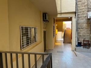 a hallway of a building with a door and a staircase at Downtown Inn Madaba in Madaba