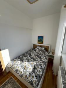 una camera da letto con un letto con copriletto floreale di Zvezda 2 Zlatar a Nova Varoš