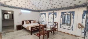 a bedroom with a bed with blue and white patterns at Heritage Luxury Camp in Sām
