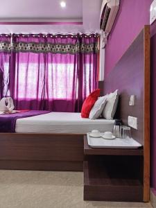 een slaapkamer met een groot bed met paarse muren bij JAZEERA RESORT in Port Blair