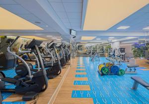 a gym with a lot of treadmills and ellipticals at Sudului ApartHotel in Bucharest