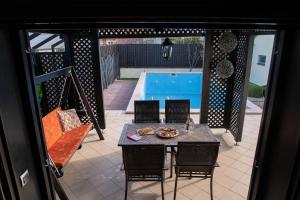 a patio with a table and chairs and a pool at Villa Markus in Slavonski Brod