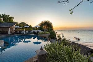 a swimming pool next to a body of water at Lembongan Island Beach Villas in Nusa Lembongan