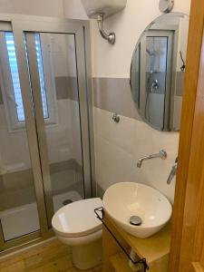 a bathroom with a toilet and a sink and a mirror at La Depandance in Marano di Napoli