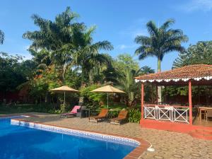 a resort with a swimming pool and a gazebo at Vila Marilyn in São Tomé