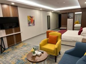 a hotel room with a bed and a couch and chair at Remaz Suites Hotel in Al Jubail
