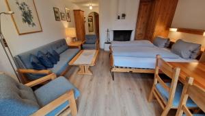 ein Wohnzimmer mit zwei Betten und einer Couch in der Unterkunft Chesa Bellaval, Haus Chamuotsch 3 1 2-Zimmerwohnung in Silvaplana