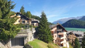 ein Gebäude an der Seite eines Hügels mit Bäumen in der Unterkunft Chesa Bellaval, Haus Chamuotsch 3 1 2-Zimmerwohnung in Silvaplana