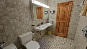 Un baño con inodoro, lavabo y espejo. en Chesa Bellaval, Haus Rizza 2-Zimmerwohnung, en Silvaplana 35 fotos más