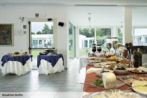 a buffet line with plates of food on tables at Seven Park Hotel Lake Como - Adults Only in Colico