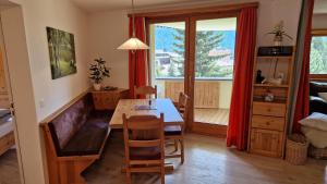 un soggiorno con tavolo da pranzo e finestra di Chesa Bellaval, Haus la Vuolp 2 1 2-Zimmerwohnung a Silvaplana
