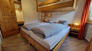 Postel nebo postele na pokoji v ubytování Chesa Bellaval, Haus la Vuolp 2 1 2-Zimmerwohnung