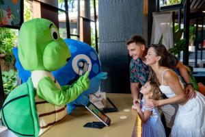 a family standing next to a table with a dinosaur toy at Novotel Phuket Kata Avista Resort and Spa in Kata Beach