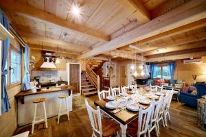 ein Esszimmer und eine Küche mit einem langen Tisch und Stühlen in der Unterkunft Marusina Chalets in Szaflary