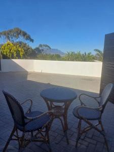 einen Tisch und zwei Stühle sowie einen Tisch und Stühle in der Unterkunft Thyme Wellness Spa and Guesthouse in Kapstadt