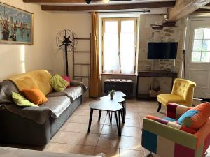 a living room with a couch and chairs and a tv at Gite La Cassine in Taillant +22 photos