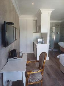 a room with a table and a chair and a sink at Thyme Wellness Spa and Guesthouse in Cape Town