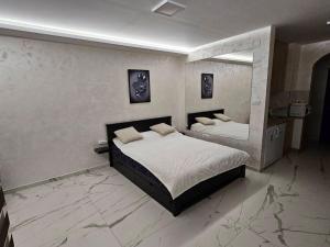 a bedroom with two beds and a mirror at Stan na dan Jovanovic in Kneževac