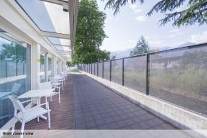 a balcony with white chairs and tables on a building at Seven Park Hotel Lake Como - Adults Only in Colico