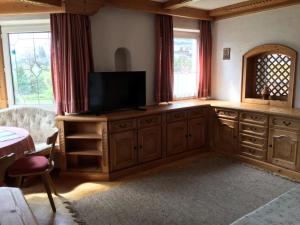 a living room with a television on a wooden cabinet at Haus Gerlinde Schernthaner in Langkampfen