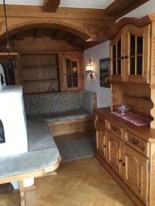 a kitchen with wooden cabinets and benches in a room at Haus Gerlinde Schernthaner in Langkampfen