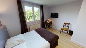 a bedroom with a bed and a window and a chair at Logis Auberge Saint Simond in Aix-les-Bains