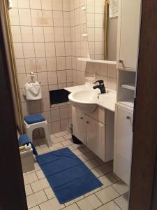 a bathroom with a white sink and a blue rug at Haus Gerlinde Schernthaner in Langkampfen +16 photos