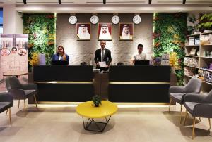 a group of people standing at a counter in a store at Grand Kingsgate Jaddaf Waterfront Hotel by Millennium in Dubai +39 photos