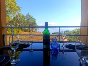 uma garrafa de vinho sentada numa mesa com copos de vinho em Ravissant T2 vue mer et massif - Les Clés de L´Estérel em Théoule-sur-Mer