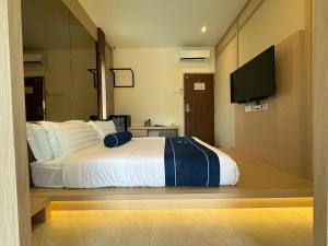 a bedroom with a bed and a flat screen tv at Muzi Boutique Hotel in Ipoh