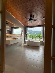 a bathroom with a tub and a ceiling fan at Muzi Boutique Hotel in Ipoh