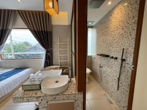 łazienka z łóżkiem, umywalką i prysznicem w obiekcie Muzi Boutique Hotel w mieście Ipoh