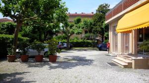 a parking lot next to a building with a yellow awning at Hotel Giulia in Marina di Massa