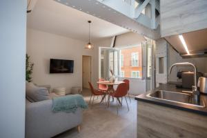 een keuken en een woonkamer met een bank en een tafel bij Diana Suites 23 in Málaga