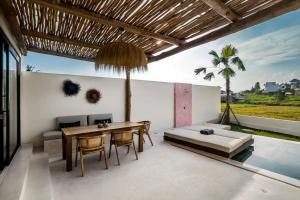 uma sala de estar com uma mesa e um sofá em VILLA ROSADO - Canggu's Hidden Gem: beautiful boutique Villa em Canggu