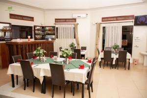 a dining room with tables and chairs in a room at Miika Eco Resort Hotel in Hoima