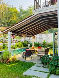 patio ze stołem i krzesłami pod pawilonem w obiekcie Casa Azul- Luxury 4bhk Assagao with private pool w mieście Vagator