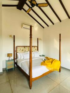 a bedroom with a large bed with a yellow blanket on it at Casa Azul- Luxury 4bhk Assagao with private pool in Vagator