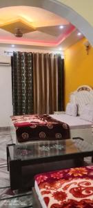 a room with two beds and a table and a window at $4 HOME STAY (5 MINT WALK FROM GOLDEN TEMPLE) in Amritsar