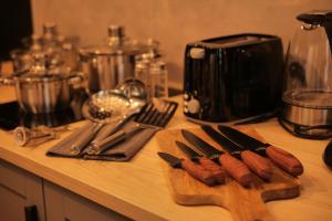 a counter with a cutting board with knives and utensils at Majestic Square View Residence in Prague