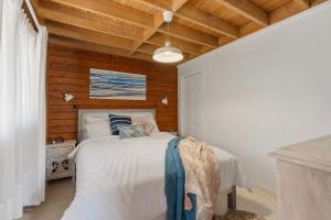 a bedroom with a bed and a wooden ceiling at The Beach Haven in Bawley Point