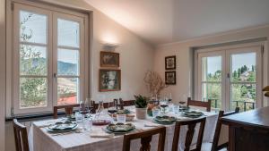 a dining room with a table and some windows at VILLA BELLAVISTA 8&1, Emma Villas in Santa Margherita Ligure