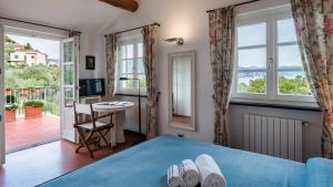 a bedroom with a bed and a desk and windows at VILLA BELLAVISTA 8&1, Emma Villas in Santa Margherita Ligure