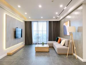 a living room with a couch and a tv at TSQ STAY Hotel Apartment in Hanoi